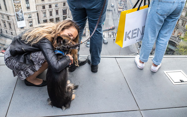 Woman hugging dog at Galeries Lafayette Paris Haussman.