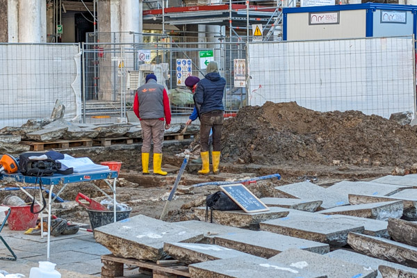 Archeologists stand amid uprooted paving stones in the Piazza San Marco during excavations.